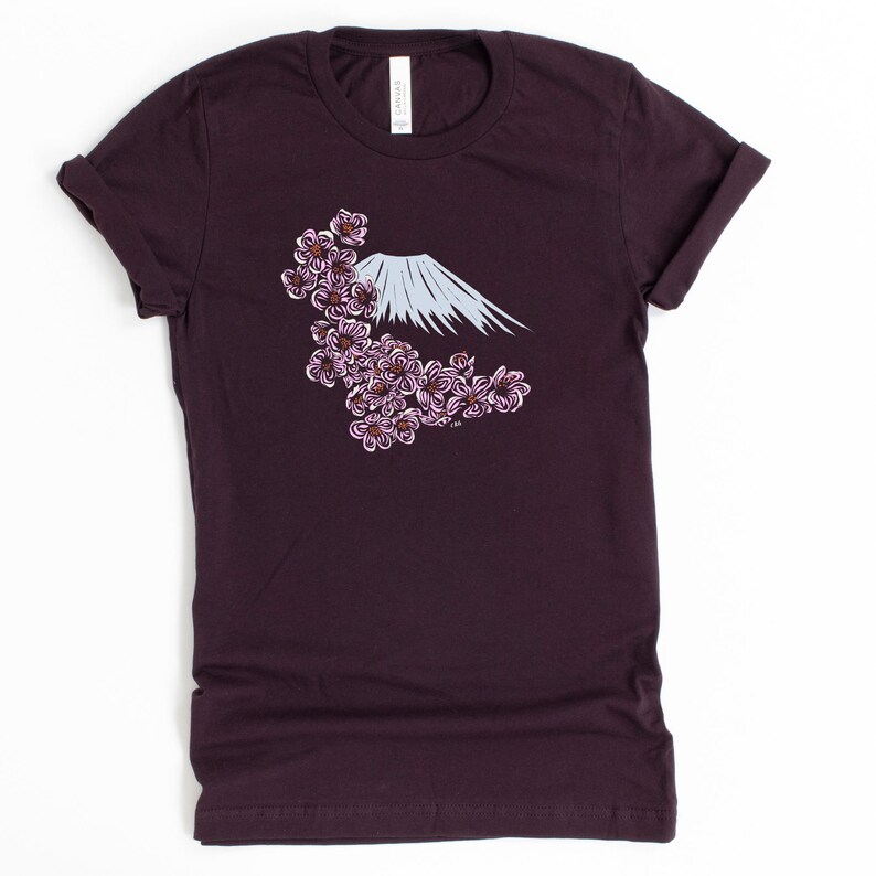 May include: A dark purple t-shirt with a white graphic of Mount Fuji and pink cherry blossoms.