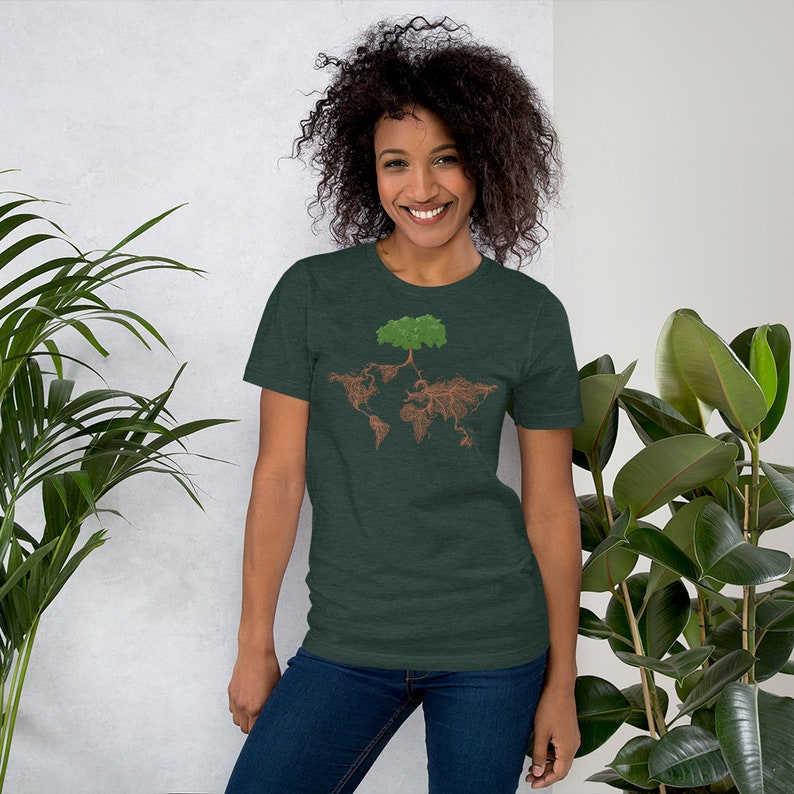 Puede incluir: Una camiseta verde oscuro con un gr&aacute;fico de un &aacute;rbol cuyas ra&iacute;ces forman la forma del mundo. El &aacute;rbol tiene hojas verdes y ra&iacute;ces marrones.