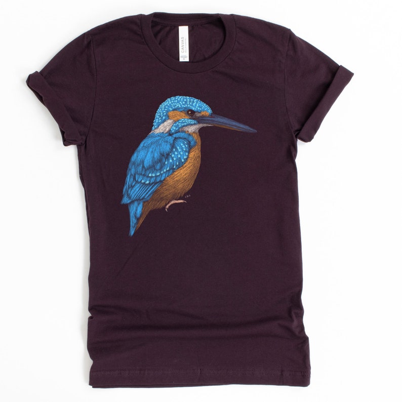 May include: A dark purple t-shirt with a blue and brown kingfisher bird illustration.