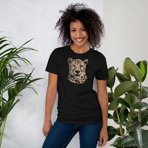 May include: A black t-shirt with a graphic print of a cheetah's face. The cheetah has a brown and black spotted coat.