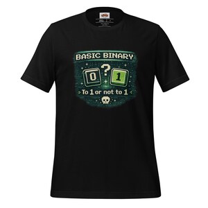 Könnte beinhalten: Schwarzes T-Shirt mit einem pixeligen Design, das "BASIC BINARY" über einer Null und einer Eins zeigt, getrennt durch ein Fragezeichen. Der Text "To 1 or not to 1" steht darunter, mit einer Totenkopf-Grafik. Das T-Shirt hat kurze Ärmel.