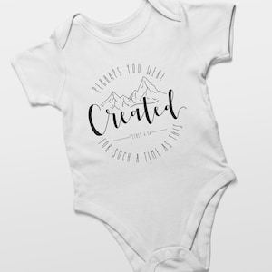 Puede incluir: Un body blanco para bebé con un gráfico negro de montañas y el texto "Perhaps you were created for such a time as this - Esther 4:14".