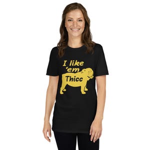 May include: Black t-shirt with the text "I like 'em Thicc" in yellow, along with a yellow bulldog graphic. The shirt is a short-sleeved crew neck.