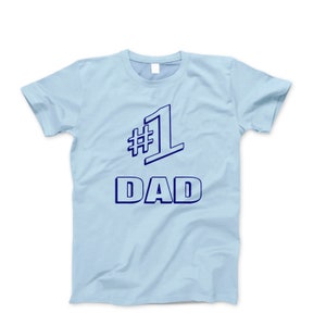 May include: Light blue t-shirt with a navy blue graphic that says "#1 DAD" in a bold, outlined font.
