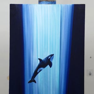 May include: A vertical rectangular canvas painting featuring a black and white orca swimming upward through a bright, light blue vertical column of light, contrasted against deep navy blue edges on both the left and right sides of the artwork.