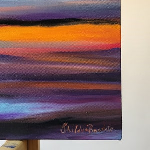 May include: An abstract painting with horizontal bands of color. The artwork features a gradient of colors, including orange, purple, blue, and black. The artist's signature, "Shilda Bondita," is visible in the lower right corner.