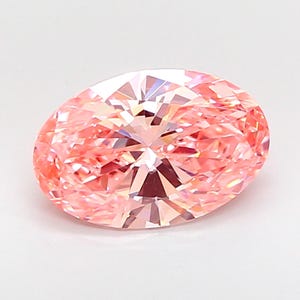 Pode incluir: Uma pedra preciosa de corte oval com um tom rosa pêssego vibrante. A pedra apresenta um arranjo complexo de facetas triangulares e em forma de pipa que criam uma superfície brilhante e reflexiva com luz em toda a gema.