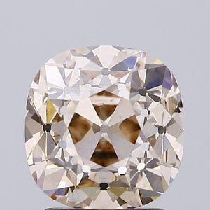 May include: A cushion-cut gemstone with a light champagne or brownish hue, featuring a complex arrangement of triangular and kite-shaped facets that create a symmetrical, star-like pattern across the surface of the stone.