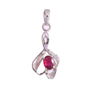 May include: A silver pendant featuring a red gemstone and clear cubic zirconia stones. The pendant is shaped like a stylised heart.