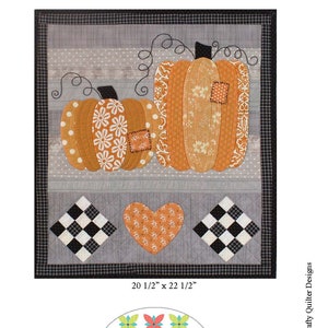 May include: A patchwork quilt featuring two orange pumpkins with different patterns, a heart, and a black and white checkered pattern. The quilt is 20 1/2 inches by 22 1/2 inches and is titled "Patchwork Pumpkins".