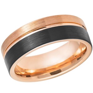 Puede incluir: Un anillo de tungsteno negro cepillado con una banda de oro rosa alrededor del borde.