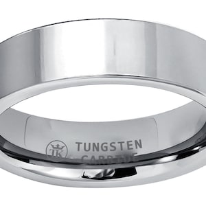 Puede incluir: Un anillo de carburo de tungsteno plateado con un borde biselado y la inscripción "TUNGSTEN CARBIDE" en el interior.