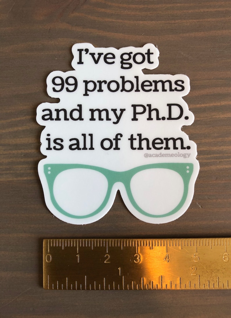 May include: White sticker with black text that reads "I've got 99 problems and my Ph.D. is all of them."  The text is followed by a pair of green glasses with black dots on the sides.