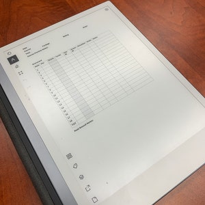 May include: A white digital notepad with a grid for recording golf scores. The notepad has a section for date, course, yardage, tees, course preview, scorecard, and post round notes.