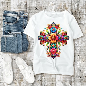May include: White t-shirt with a colorful floral cross design. The cross is made up of flowers in shades of pink, yellow, blue, green, and orange.