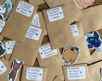 May include: A collection of brown paper envelopes with various stickers attached. The stickers feature different designs, including a cartoon character, a cat, a bird, and a creature from a movie. The envelopes are labeled with the text "B-Grade Mystery Sticker" and different sizes, such as "small", "medium", and "holographic".