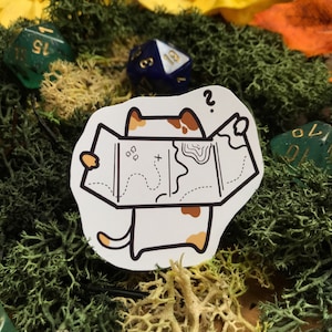 Può includere: Un adesivo bianco con un gatto dei cartoni animati con macchie marroni, che tiene in mano una mappa e sembra confuso. La mappa presenta una linea tratteggiata, simboli e curve di livello. L'adesivo è circondato da muschio verde, fiori gialli e dadi.