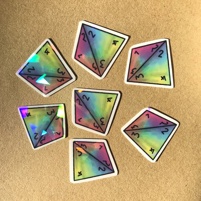 May include: Eight iridescent holographic stickers shaped like a four-sided die with numbers 1, 2, 3, 4, 7, and 22 on each side.