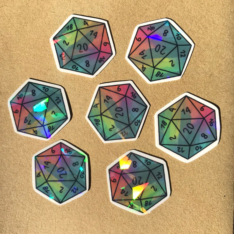 May include: Seven iridescent holographic stickers of a twenty-sided die with black numbers. The stickers are arranged in a circle on a brown surface.