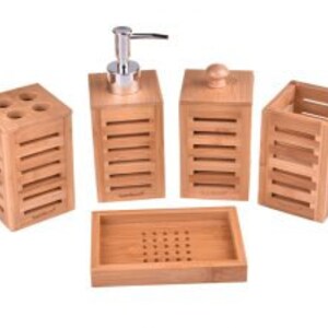 May include: A set of four bamboo bathroom accessories, including a soap dispenser, toothbrush holder, tumbler, and soap dish. The accessories are all made of natural bamboo and have a sleek, modern design.