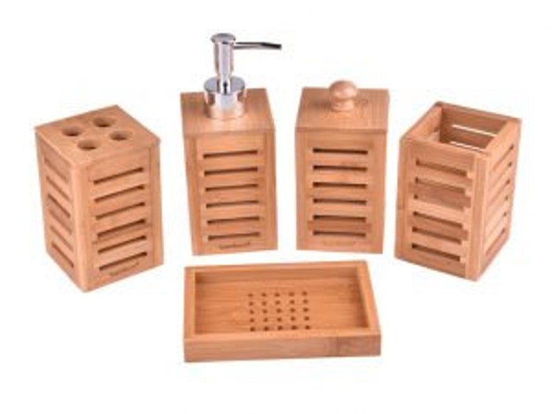 May include: A set of four bamboo bathroom accessories, including a soap dispenser, toothbrush holder, tumbler, and soap dish. The accessories are all made of natural bamboo and have a sleek, modern design.