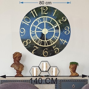Könnte beinhalten: Eine große, runde Wanduhr mit einem Durchmesser von 80 cm, mit einem schwarzen Zifferblatt in Marmoroptik und goldenen römischen Ziffern. Die Uhr ist an einer weißen Wand über einem dekorativen Schrank angebracht. Die Zeiger der Uhr zeigen auf 10:08.