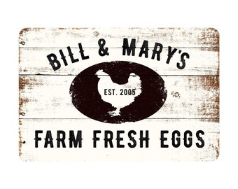 May include: White wooden sign with black text that reads "Bill & Mary's Farm Fresh Eggs" with a black oval containing a white silhouette of a chicken and the text "Est. 2005".
