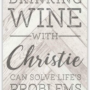 May include: A white metal sign with a distressed woodgrain background. The sign reads "Drinking wine with Christie can solve life's problems."