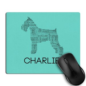 May include: A turquoise mousepad with a black silhouette of a dog made from the word "Schnauzer" repeated many times. The name "Charlie" is printed below the dog silhouette.