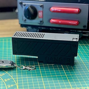 Peut inclure: Un appareil rectangulaire noir avec une télécommande argentée. L'appareil est doté d'un motif rayé noir et blanc et du texte "DANGER HIGH VOLTAGE" imprimé dessus.