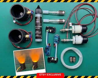 May include: A set of electronic components including two black cylindrical housings, a bottle of fog liquid, two pumps with red and black wiring, circuit boards, clear tubing, and two nozzles. A small photo shows the components emitting orange smoke.