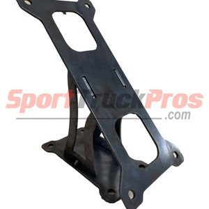May include: A black metal bracket with a rectangular design and multiple holes for mounting. The bracket has a unique angled shape and features the text "SportTruckPros.com".