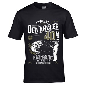 May include: Black t-shirt with a green graphic design that says "Genuine Good Fella Old Angler 40 Years in the Making". The graphic also includes a fish, a fishing rod, and the text "Because size matters Master Baiter Born to Fish A Living Legend".