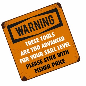 May include: A rusty orange metal sign with the text "WARNING THESE TOOLS ARE TOO ADVANCED FOR YOUR SKILL LEVEL PLEASE STICK WITH FISHER PRICE" in black and white lettering.