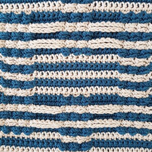 May include: A close-up of a crocheted fabric with alternating stripes of teal blue and cream.