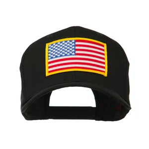 May include: Black baseball cap featuring a patch of the American flag. The flag design includes blue, white, and red colors with a yellow border. The cap is a classic style with a curved brim.