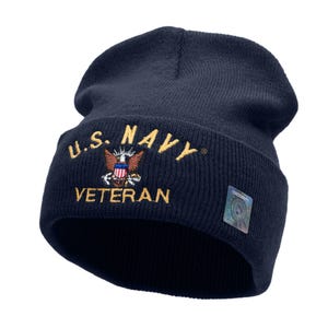 May include: A navy blue knit beanie with the words "U.S. NAVY VETERAN" embroidered in gold on the front. The beanie features a small embroidered American flag with an eagle above it.