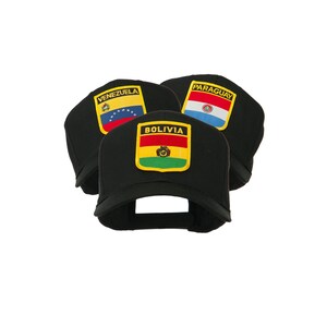 May include: Three black baseball caps with embroidered patches featuring the flags of Venezuela, Bolivia, and Paraguay. The patches are rectangular with the country names above the flag designs. The caps are angled, showcasing the patches.