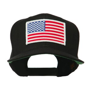 Peut inclure: Casquette de baseball noire avec un écusson rectangulaire représentant le drapeau américain. Le drapeau présente des rayures rouges et blanches et un champ bleu avec des étoiles blanches. La visière de la casquette a un dessous vert.