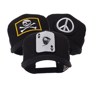 Peut inclure: Trois casquettes de camionneur noires avec différents écussons. L'une arbore un crâne et des os croisés sur un rectangle jaune, une autre un symbole de paix, et la troisième une carte d'as de pique avec un crâne.