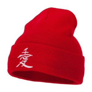 May include: A vibrant red beanie hat featuring a white embroidered Japanese character. The hat is made from a ribbed knit fabric. A winter accessory.