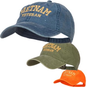 May include: Three cotton baseball caps in different colors. The caps are all embroidered with the text "Vietnam Veteran" in a gold color. The caps are blue, green, and orange.