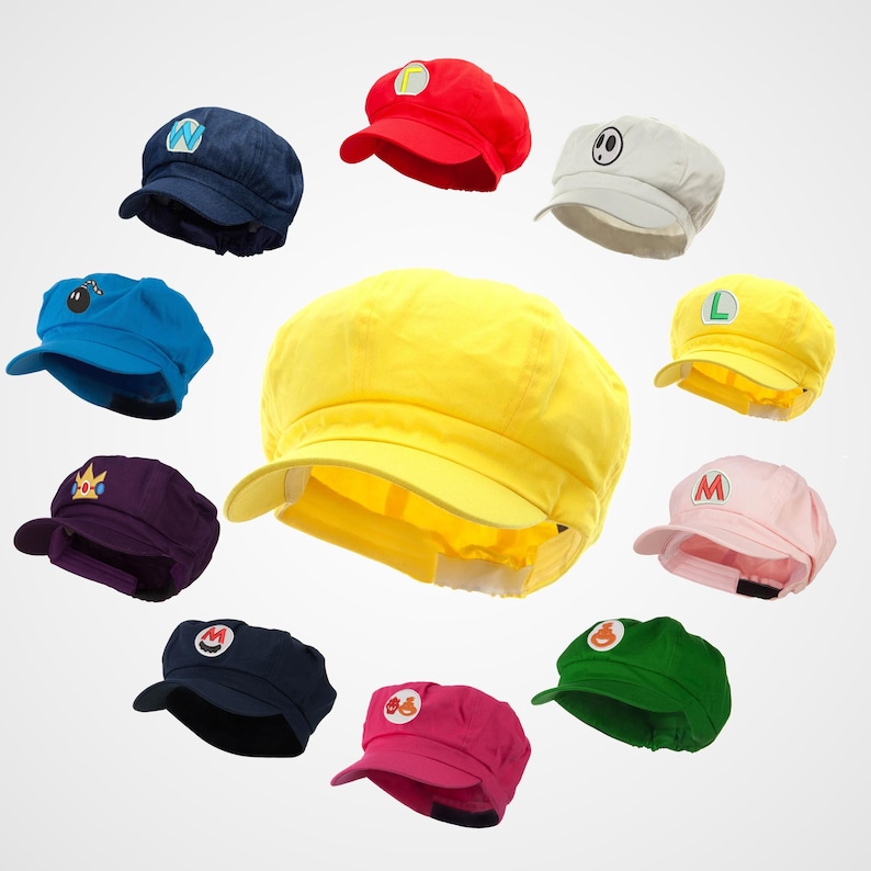 May include: A set of 10 colorful hats with different embroidered designs. The hats are all the same style, with a flat top and a brim that curves down around the sides. The designs include a crown, a star, a mushroom, a letter L, a letter M, a letter N, a bomb, a ghost, and a question mark.