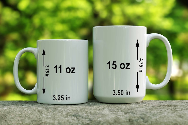 May include: Two white ceramic mugs with black markings. The smaller mug is 11 oz and 3.25 inches wide. The larger mug is 15 oz and 3.5 inches wide.