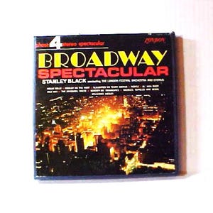 May include: A CD case for "Broadway Spectacular" by Stanley Black. The cover features the title in yellow and red, with a cityscape background. The CD is a stereo spectacular.