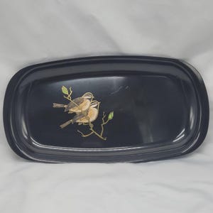 May include: A black rectangular serving tray with rounded corners. The tray features a decorative illustration of two birds perched on a branch with green leaves. The birds have brown and tan feathers.