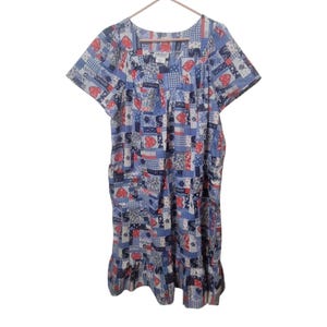 May include: A short-sleeved, patchwork-style dress in shades of blue, white, and red. The dress features a variety of patterns, including hearts, stars, and floral designs. It has a ruffled hemline and a V-neck.