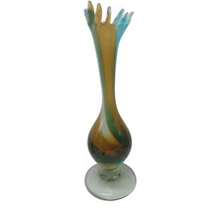 May include: A tall, colorful glass vase with a flared top. The vase features a bulbous base and a slender neck, with a mix of brown, yellow, green, and blue hues. The vase stands on a clear, circular base, showcasing a unique, artistic design.