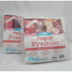 May include: Two packages of Poly-fil Premier Ultra Plush Pillow Inserts. The white packaging has red and blue text, with a picture of pillows in shades of red, pink, and cream. Each pillow insert measures 12 inches (30.4 cm).
