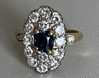May include: A gold ring with a blue sapphire surrounded by a halo of diamonds.